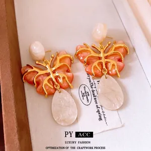 Vintage gold hollow butterfly earrings with marbled resin drops on card