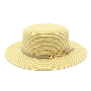 Detail showing the fine weave texture and leather band with gold buckle on a straw hat