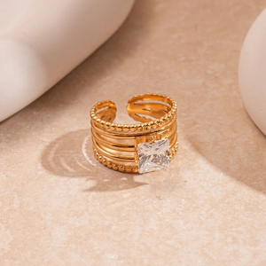 Close-up of golden multi-layer open ring with square zircon and beaded texture detail