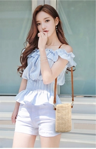 Close-up of a woven straw crossbody phone bag with brown strap for summer style