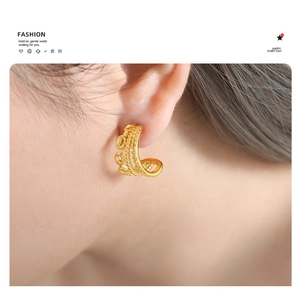 Detail of 18K gold-plated triple-layered C-shaped textured earrings on model