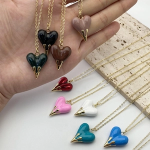 Handheld heart pendant necklaces in multiple colors with elegant gold metal flame detail