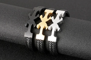 Detailed close-up of woven leather anchor bracelets in black, gold and silver finish