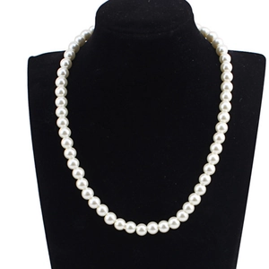 Classic single-strand white pearl necklace displayed on a black neck bust model
