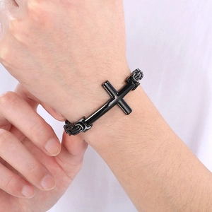 Detailed close-up of a black stainless steel cross bracelet on a male model wrist
