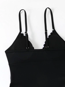 Close-up of black V-neck swimsuit back with adjustable spaghetti straps and neat stitching