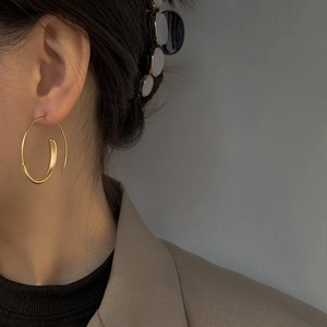 Golden matte twisted earrings with elegant spiral design on female model for daily wear