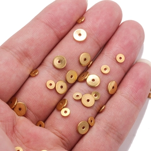 PVD 18K gold plated stainless steel spacer beads in various sizes held on palm