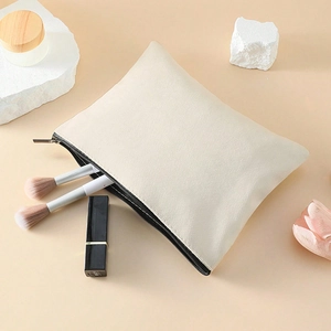 Minimalist cream canvas makeup bag with black zipper and cosmetic storage items