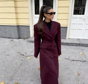 Dettaglio del cappotto di lana bordeaux con vita alta e bottoni a monopetto eleganti