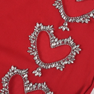 Détail de robe rouge en tricot côtelé avec strass argentés étincelants en forme de cœur