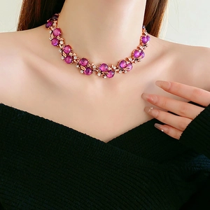Detail of vintage rose gold necklace with purple gemstones and rhinestone flower vine