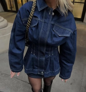 Détail d'une robe en denim bleu foncé avec surpiqûres blanches et design cintré
