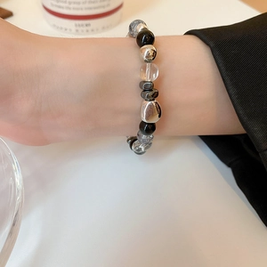 Detail of dark style hematite crystal beaded bracelet with metallic irregular charms