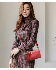 Close-up of red genuine leather crossbody bag with lychee texture and silver hardware