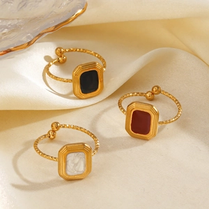 Minimalist square geometric rings with black, red and white enamel on a silk background