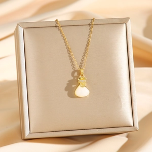 Gouden titanium ketting met witte jade gelukszak hanger op luxe satijnen achtergrond