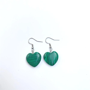 Detail view of heart-shaped malachite stone earrings with silver metal hooks for women
