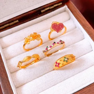 Detail of vintage gold plated flower rings set with colorful gemstones in a jewelry box