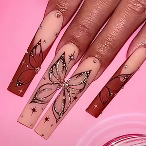 Long coffin nails with brown butterfly art, glitter, and rhinestones on nude base