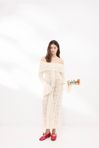 Detailed close-up of white off-the-shoulder crochet knit dress with elegant texture