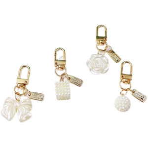 Elegant gold keychain set with pearl charms, ribbon bow and white rose flower pendants