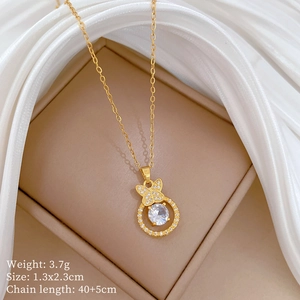 Close-up of gold butterfly and circle pendant with crystals in a beige jewelry box