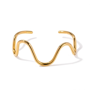 Polished wavy gold cuff bracelet featuring a minimalist open design with a sleek mirror finish