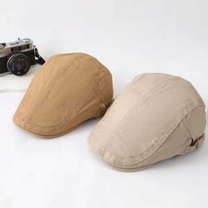 Detail view of khaki and beige cotton canvas beret hats with visible stitching on white base