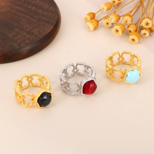 Detailed shot of hollow bear-shaped rings with colorful gemstones on a wooden tray