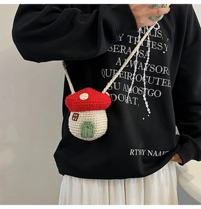 Crossbody knitted mushroom bag showing handmade details and cute miniature house design
