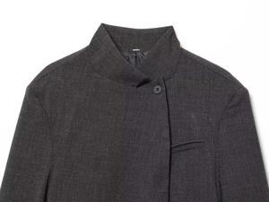Detailed close-up of dark grey blazer featuring mandarin collar and fine twill texture