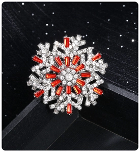 Detailed view of luxury rotating snowflake brooch with red and white crystals