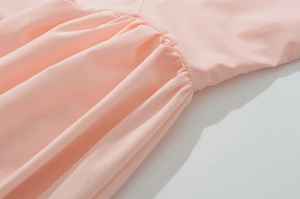 Detailed macro view of pink summer dress fabric with pleated texture and seams