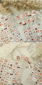 Macro view of cute cartoon puppy nail stickers with heart and bear patterns in brown tones