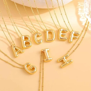 Detail of 18K gold-plated balloon letter pendants A-H on delicate stainless steel chains