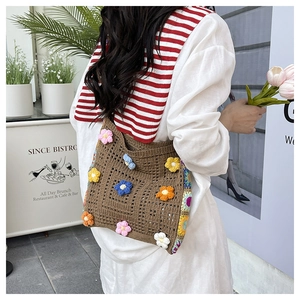 Detail of hand-crocheted shoulder bag with 3D colorful flowers for summer beach style
