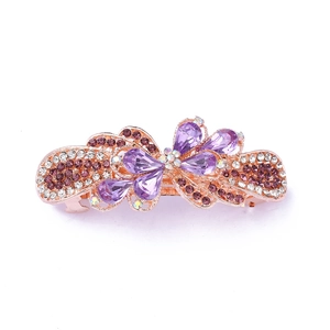 Macro shot of rose gold hair clip featuring purple teardrop crystals and amber rhinestones