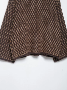 Close-up of brown geometric knit pattern on the hem and cuff of the wool sweater