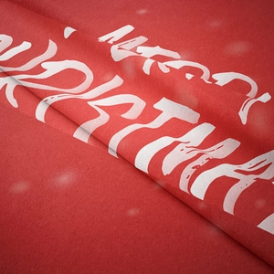 Detailed texture of red Christmas tapestry with white Merry Christmas lettering design