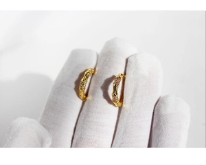 Detailed close-up of gold-plated bamboo hoop earrings with sparkling crystal accents