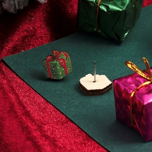 Detail of wooden Christmas gift box earrings with red ribbons and metal studs
