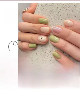 Macro detail of checkerboard press-on nails with green floral patterns and glossy finish