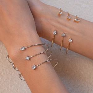Détail de bracelets ouverts ajustables avec zircons en forme d'étoile et de goutte