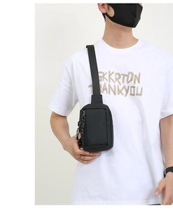 Detail view of the waterproof black crossbody chest bag with adjustable strap and zippers