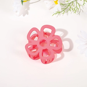 Detail view of pink matte flower hair claw clip with durable metal spring on white background
