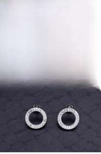 Detailed view of silver stainless steel round stud earrings with pave-set white zircons
