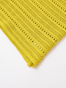 Macro detail of vibrant yellow knit fabric featuring hollow out crochet texture and pattern