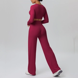 Detail view of burgundy yoga set featuring long sleeve crop top and wide-leg trousers