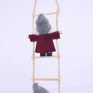 Detail of wool felt Christmas gnome with red robe and knit hat on a wooden rope ladder